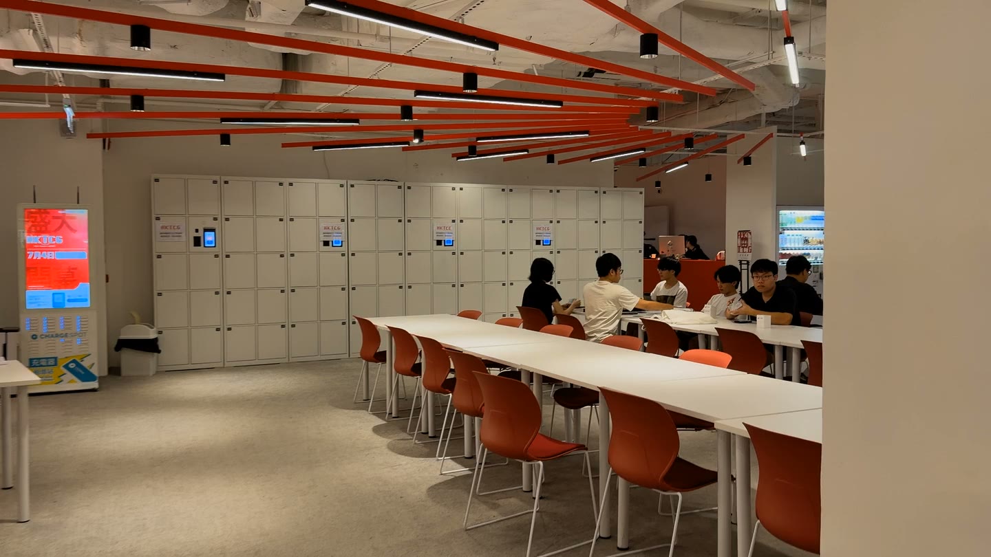 Players sit across long tables in HKTCG’s red-and-white play area.